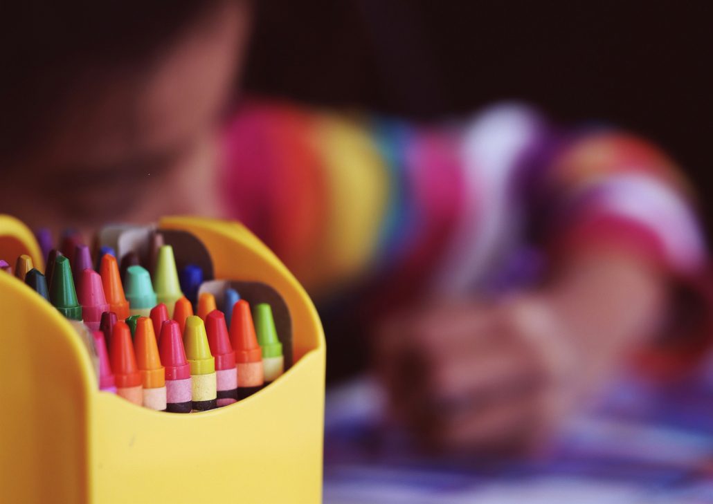 Child using crayons in a Missouri child care assistance program setting.